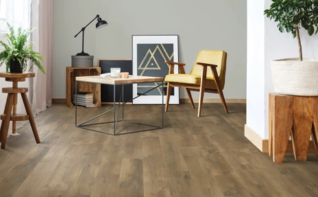 Modern and stylish living room featuring beige laminate flooring, a sleek yellow chair, and natural light streaming through large windows.